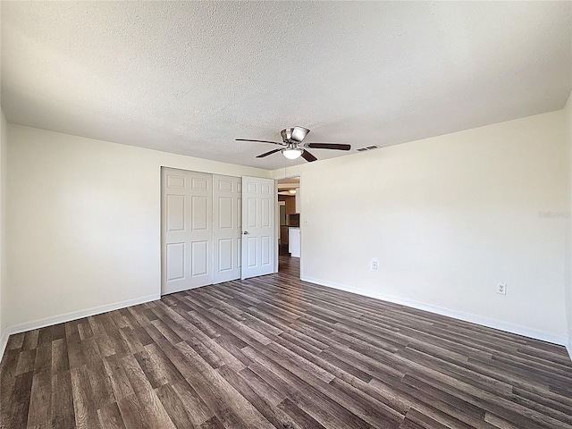 6341 Hyperion Dr, Port Richey, FL 34668 - unfurnished bedroom with dark wood finished floors, a closet, ceiling fan, and a textured ceiling