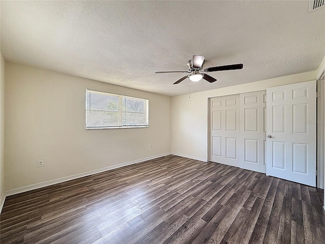 6341 Hyperion Dr, Port Richey, FL 34668 - unfurnished bedroom featuring a textured ceiling, dark wood finished floors, a closet, and a ceiling fan