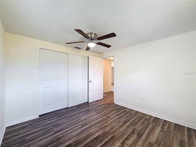 6341 Hyperion Dr, Port Richey, FL 34668 - unfurnished bedroom with dark wood-type flooring, a closet, a textured ceiling, and ceiling fan
