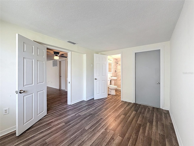 6341 Hyperion Dr, Port Richey, FL 34668 - unfurnished bedroom with dark wood finished floors, a textured ceiling, and connected bathroom