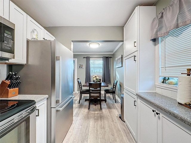 11722 Carissa Ln Unit 49A, New Port Richey, FL 34654 - kitchen featuring appliances with stainless steel finishes, light wood-style flooring, white cabinets, and ornamental molding