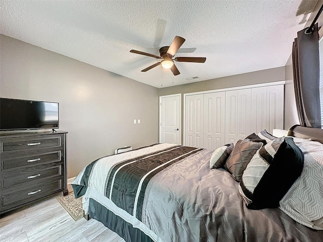 11722 Carissa Ln Unit 49A, New Port Richey, FL 34654 - bedroom featuring a ceiling fan, a textured ceiling, a closet, and light wood-style floors