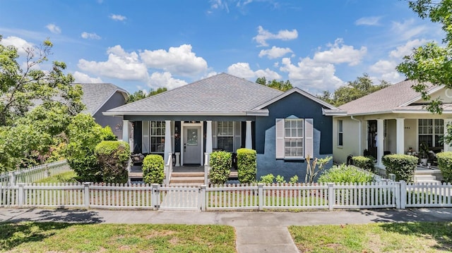 3450 Ferrell St, New Port Richey, FL 34655 - view of front of home with a porch, stucco siding, a gate, a fenced front yard, and a shingled roof