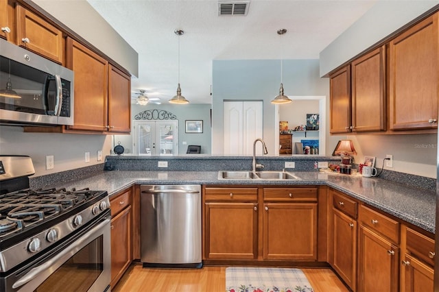 3450 Ferrell St, New Port Richey, FL 34655 - kitchen with appliances with stainless steel finishes, brown cabinetry, decorative light fixtures, and a ceiling fan