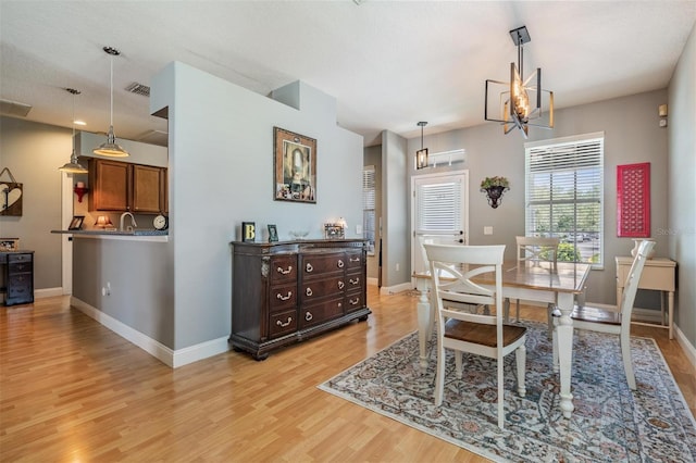 3450 Ferrell St, New Port Richey, FL 34655 - dining area featuring light wood finished floors and a chandelier