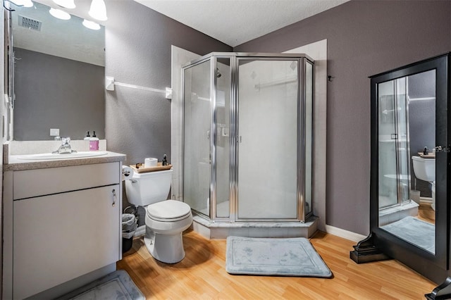 3450 Ferrell St, New Port Richey, FL 34655 - bathroom featuring a textured wall, wood finished floors, a shower stall, and vanity