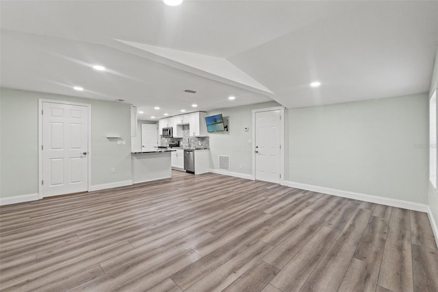 5724 Casson Ave, New Port Richey, FL 34652 - unfurnished living room featuring recessed lighting, light wood-type flooring, and lofted ceiling