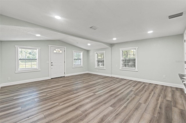 5724 Casson Ave, New Port Richey, FL 34652 - unfurnished living room with lofted ceiling, wood finished floors, and recessed lighting