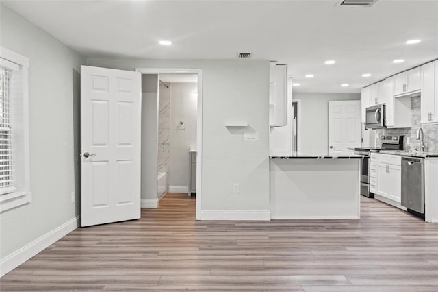 5724 Casson Ave, New Port Richey, FL 34652 - kitchen featuring stainless steel appliances, white cabinetry, recessed lighting, and light wood finished floors