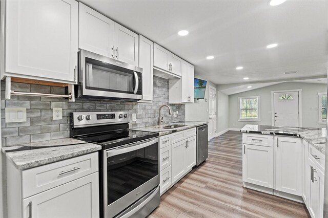 5724 Casson Ave, New Port Richey, FL 34652 - kitchen featuring stainless steel appliances, light wood-style flooring, white cabinetry, tasteful backsplash, and recessed lighting
