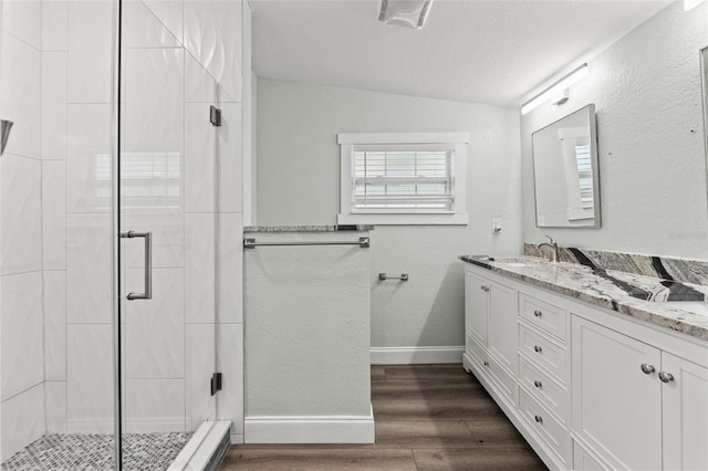 5724 Casson Ave, New Port Richey, FL 34652 - bathroom with double vanity, a stall shower, wood finished floors, and lofted ceiling