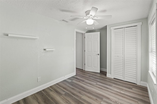 5724 Casson Ave, New Port Richey, FL 34652 - unfurnished bedroom featuring wood finished floors, a closet, a textured ceiling, and a ceiling fan