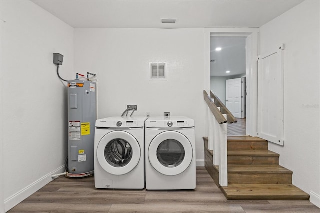 5724 Casson Ave, New Port Richey, FL 34652 - laundry room featuring water heater, washing machine and clothes dryer, and wood finished floors