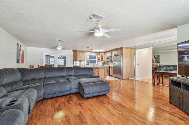 1071 Lexington Ct, Largo, FL 33771 - living room featuring a ceiling fan, light wood-style floors, and a textured ceiling