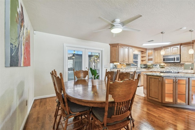 1071 Lexington Ct, Largo, FL 33771 - dining room featuring ceiling fan, light wood-type flooring, a textured ceiling, and french doors