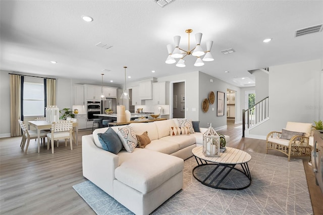 823 Emerald Grove Dr, Apopka, FL 32703 - living area with a chandelier, light wood-style flooring, stairs, and recessed lighting