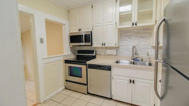 423 E Kaley St, Orlando, FL 32806 - kitchen with appliances with stainless steel finishes, backsplash, light countertops, light tile patterned floors, and white cabinets