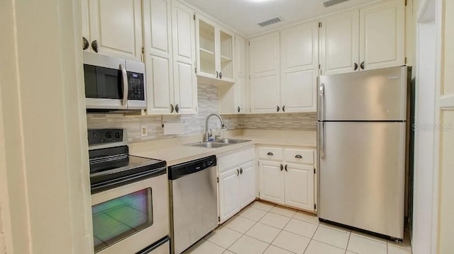423 E Kaley St, Orlando, FL 32806 - kitchen with stainless steel appliances, light countertops, light tile patterned floors, and tasteful backsplash