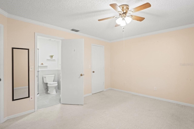 6702 Dartmoor Ln Unit 7A, New Port Richey, FL 34653 - unfurnished bedroom featuring a textured ceiling, ensuite bath, crown molding, carpet, and a ceiling fan