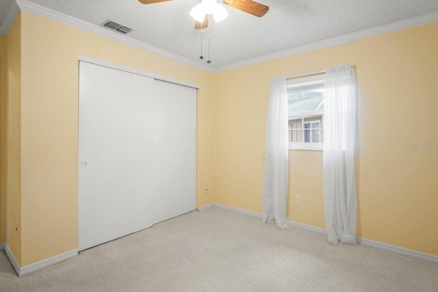 6702 Dartmoor Ln Unit 7A, New Port Richey, FL 34653 - unfurnished bedroom featuring carpet, crown molding, a closet, a textured ceiling, and a ceiling fan