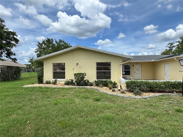 12104 Boynton Ln, New Port Richey, FL 34654 - view of front facade featuring stucco siding and a front yard