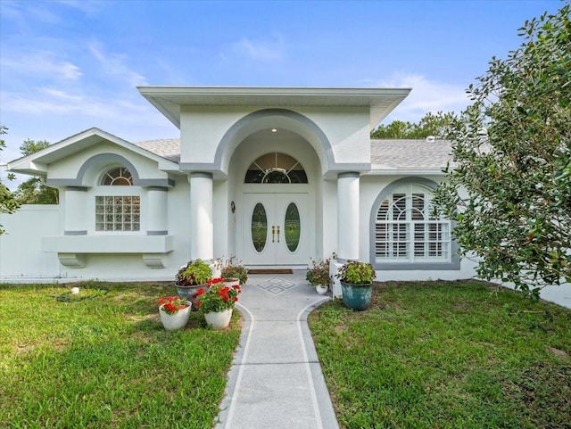 15430 Oakcrest Cir, Brooksville, FL 34604 - doorway to property with roof with shingles, a yard, and stucco siding