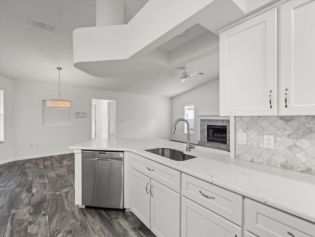 15430 Oakcrest Cir, Brooksville, FL 34604 - kitchen with dishwasher, ceiling fan, backsplash, white cabinetry, and a fireplace