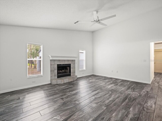15430 Oakcrest Cir, Brooksville, FL 34604 - unfurnished living room featuring dark wood-style flooring, a ceiling fan, a fireplace, and a textured ceiling