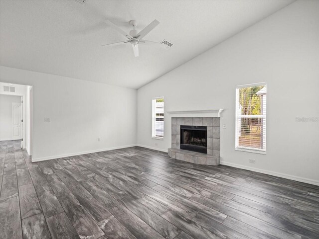 15430 Oakcrest Cir, Brooksville, FL 34604 - unfurnished living room featuring dark wood-type flooring, a tile fireplace, a ceiling fan, and high vaulted ceiling