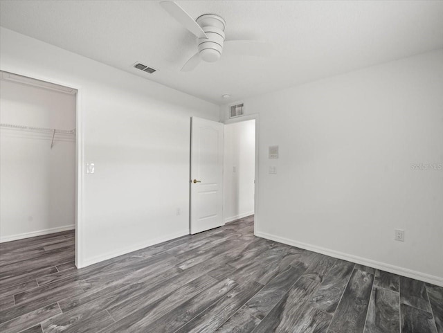 15430 Oakcrest Cir, Brooksville, FL 34604 - unfurnished bedroom with dark wood-type flooring, a closet, and a ceiling fan