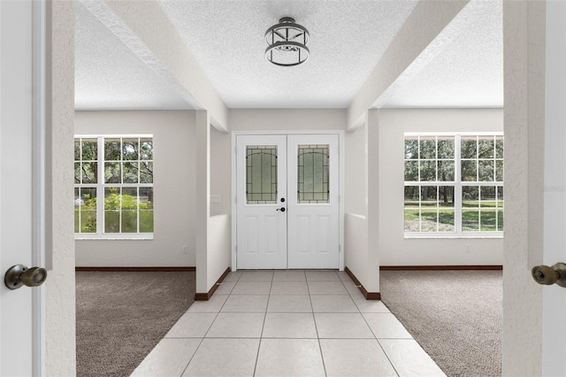 14645 Spellman Ct, Spring Hill, FL 34610 - entryway featuring light carpet, a textured ceiling, healthy amount of natural light, and light tile patterned floors