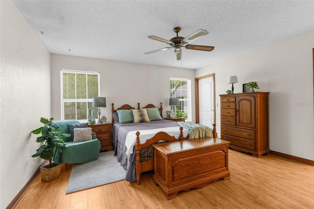 14645 Spellman Ct, Spring Hill, FL 34610 - bedroom featuring light wood finished floors, a textured ceiling, a textured wall, and a ceiling fan