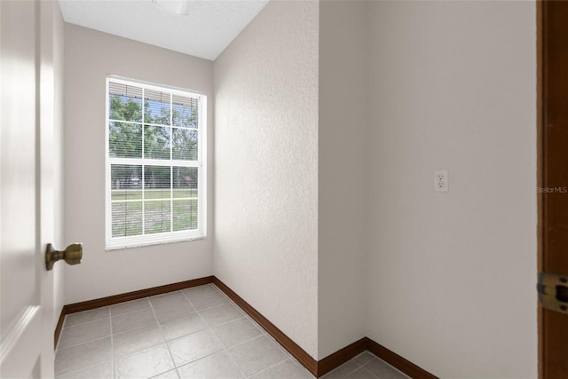 14645 Spellman Ct, Spring Hill, FL 34610 - empty room with plenty of natural light, light tile patterned floors, and a textured wall