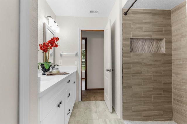 14645 Spellman Ct, Spring Hill, FL 34610 - bathroom with double vanity, tiled shower, and a textured ceiling