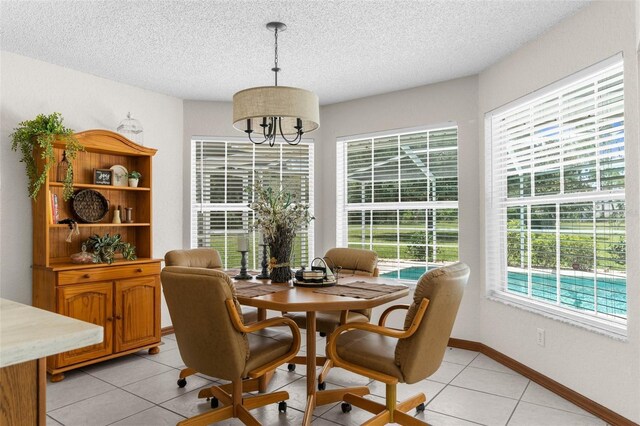 14645 Spellman Ct, Spring Hill, FL 34610 - dining area featuring a textured ceiling, light tile patterned flooring, and a chandelier