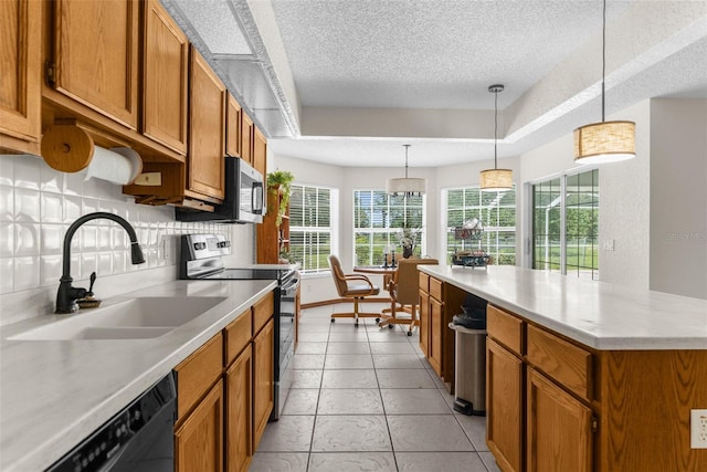 14645 Spellman Ct, Spring Hill, FL 34610 - kitchen with appliances with stainless steel finishes, brown cabinets, a textured ceiling, light countertops, and a kitchen island