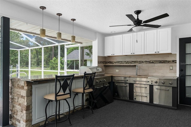 14645 Spellman Ct, Spring Hill, FL 34610 - kitchen with ceiling fan, a sunroom, white cabinetry, decorative backsplash, and a textured ceiling