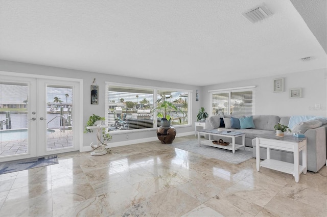3701 Corsair Ct, New Port Richey, FL 34652 - living area featuring a textured ceiling, marble tiled floors, plenty of natural light, and french doors