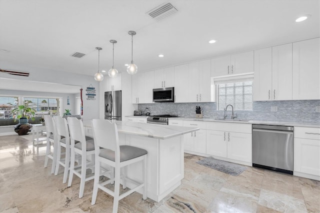 3701 Corsair Ct, New Port Richey, FL 34652 - kitchen featuring appliances with stainless steel finishes, backsplash, a center island, plenty of natural light, and recessed lighting