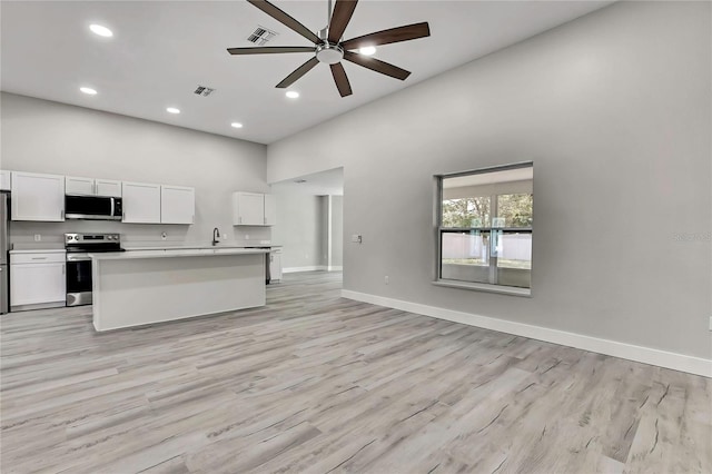 4360 Talco Ave, Spring Hill, FL 34609 - kitchen featuring stainless steel appliances, open floor plan, ceiling fan, high vaulted ceiling, and white cabinetry