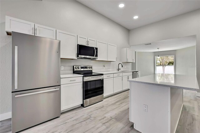 4360 Talco Ave, Spring Hill, FL 34609 - kitchen with appliances with stainless steel finishes, white cabinets, light wood-style floors, light countertops, and recessed lighting