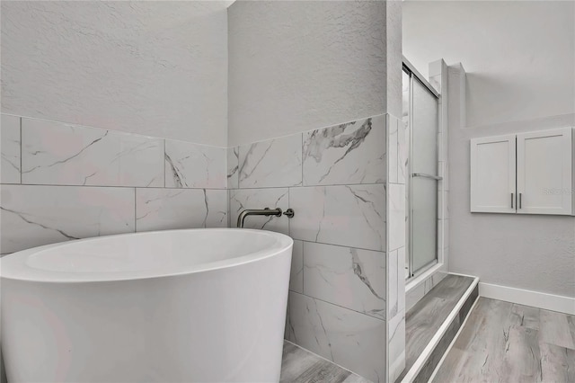 4360 Talco Ave, Spring Hill, FL 34609 - bathroom with wood finished floors, a soaking tub, tile walls, and a shower stall
