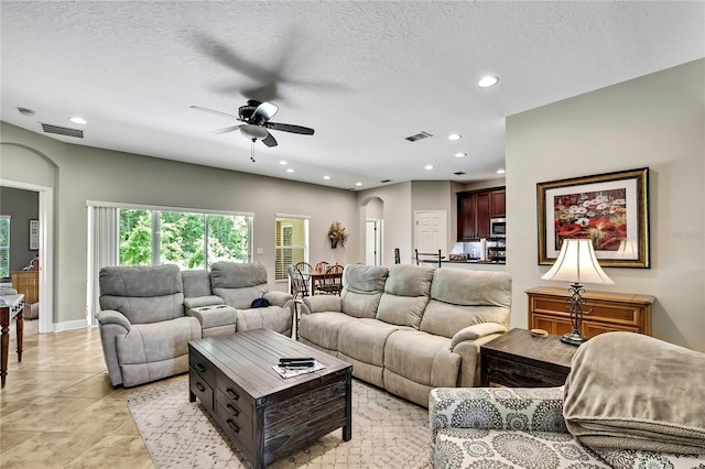 11101 Ragsdale Ct, New Port Richey, FL 34654 - living area with arched walkways, a ceiling fan, recessed lighting, light tile patterned floors, and a textured ceiling