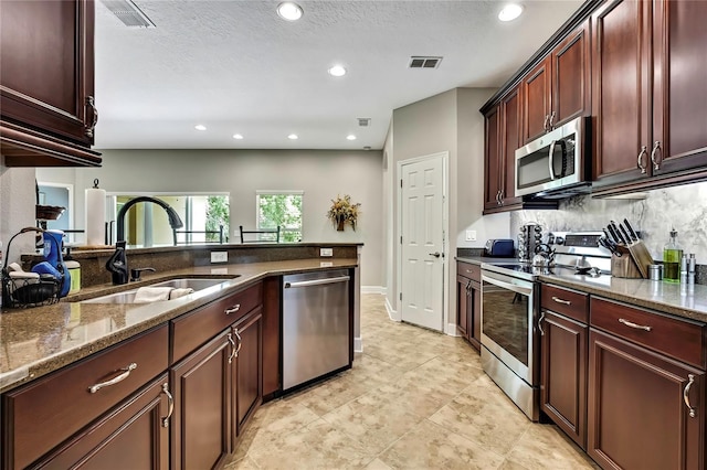 11101 Ragsdale Ct, New Port Richey, FL 34654 - kitchen featuring stainless steel appliances, tasteful backsplash, dark stone counters, recessed lighting, and light tile patterned floors