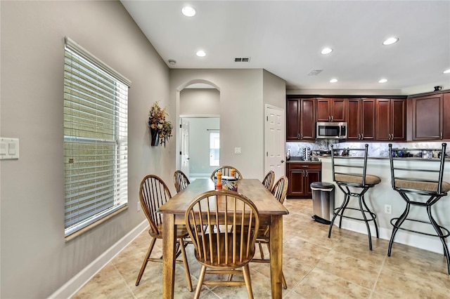 11101 Ragsdale Ct, New Port Richey, FL 34654 - dining area featuring arched walkways, recessed lighting, and light tile patterned floors