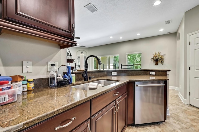 11101 Ragsdale Ct, New Port Richey, FL 34654 - kitchen with stainless steel dishwasher, dark stone countertops, recessed lighting, light tile patterned floors, and a peninsula