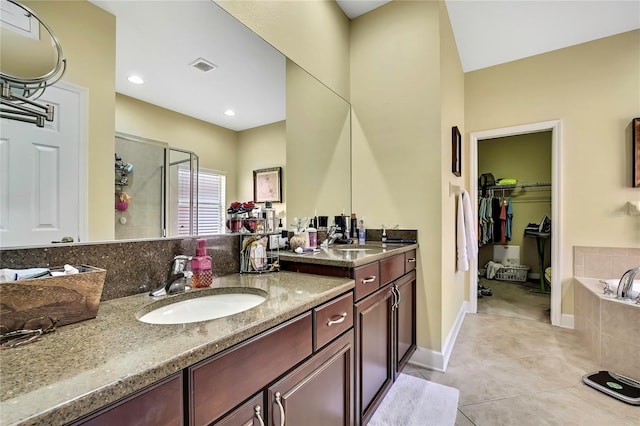 11101 Ragsdale Ct, New Port Richey, FL 34654 - full bathroom with double vanity, a shower stall, tile patterned flooring, a bath, and a walk in closet