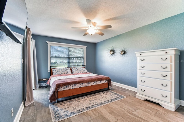 3745 Teeside Dr Unit 3745, New Port Richey, FL 34655 - bedroom featuring a textured ceiling, a textured wall, light wood-type flooring, and a ceiling fan