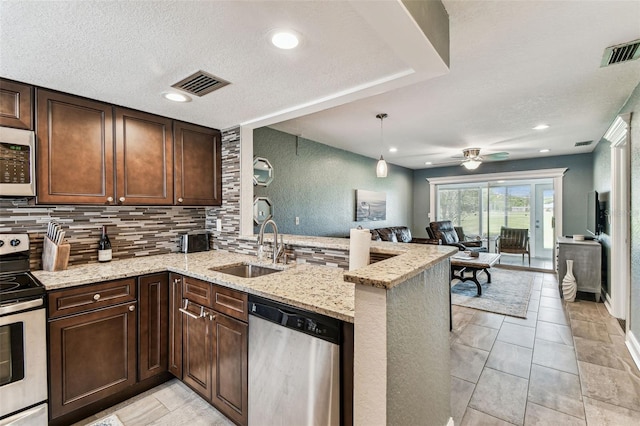 3745 Teeside Dr Unit 3745, New Port Richey, FL 34655 - kitchen with stainless steel appliances, open floor plan, a peninsula, a ceiling fan, and tasteful backsplash