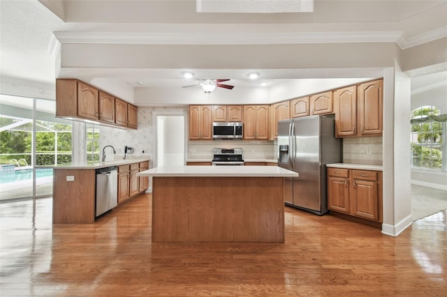 2519 Shipston Ave, New Port Richey, FL 34655 - kitchen featuring stainless steel appliances, ornamental molding, light wood-style floors, light countertops, and tasteful backsplash